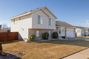 View of front of home featuring a garage and a front lawn