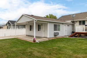 Back of house with fence, stairs, a yard, and a patio