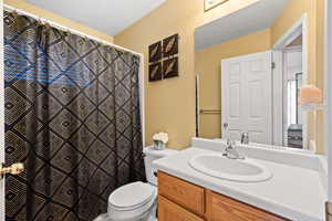 Bathroom featuring vanity, toilet, and a textured ceiling