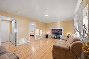 Living room featuring light hardwood / wood-style flooring and a textured ceiling