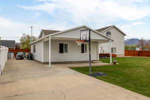 Bungalow-style home with a fenced backyard, a mountain view, and a front yard