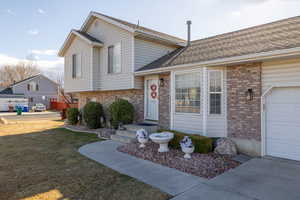 Tri-level home with a garage and a front lawn