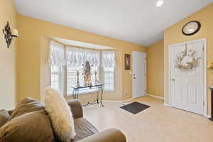 Foyer entrance with vaulted ceiling, a wealth of natural light, and light tile patterned floors