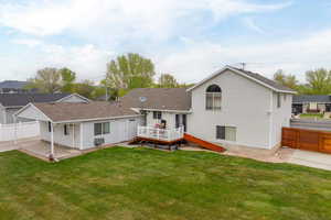 Back of house with fence, a yard, and a deck