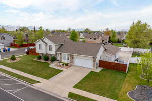 View of front facade featuring brick siding, a residential view, a front lawn, and a garage