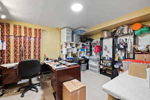 Carpeted office space with a textured ceiling