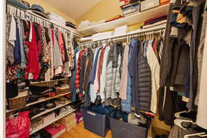 Spacious closet with lofted ceiling and light hardwood / wood-style flooring