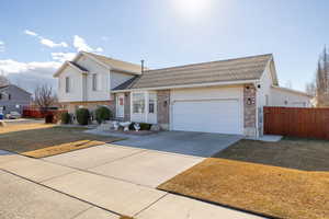 Tri-level home with a garage and a front lawn