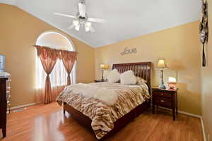 Bedroom featuring lofted ceiling, wood-type flooring, and ceiling fan