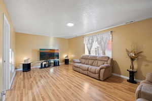 Living room featuring a textured ceiling and light wood-type flooring