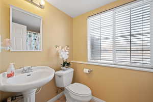 Bathroom featuring a healthy amount of sunlight, toilet, and sink