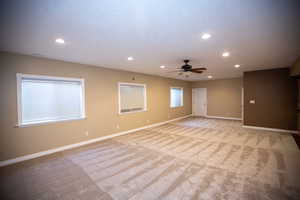 Carpeted family room featuring ceiling fan and separate entrance