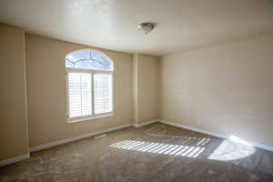 Carpeted main bedroom #1 featuring a textured ceiling