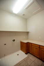 Laundry room with cabinets, washer hookup, hookup for an electric  and gas dryer, and light tile patterned floors