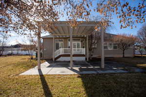 Rear view of house featuring a pergola, central air condition unit, a patio area, and a lawn