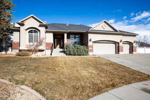 Ranch-style house featuring a 3-car garage and a front lawn and wide driveway.