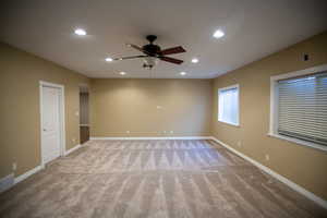 Family room with light colored carpet and ceiling fan