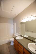 Full bathroom featuring tile patterned flooring, vanity, toilet, and tiled shower / bath