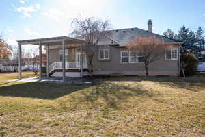 Back of property featuring a lawn and a patio