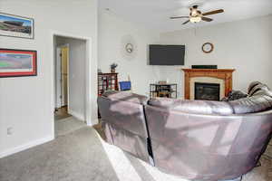 Living room with light carpet, a fireplace, and ceiling fan