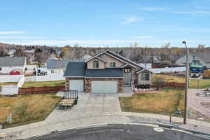 View of front of property featuring a garage and a front lawn