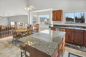 Kitchen featuring a center island, sink, stainless steel dishwasher, and plenty of natural light