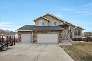 View of front of home featuring a mountain view, a garage, and a front lawn