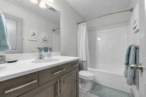 Full bathroom with vanity, toilet, and shower / bathtub combination with curtain