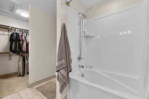 Bathroom with tile patterned floors and bathing tub / shower combination