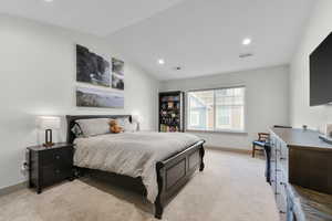 Carpeted bedroom with lofted ceiling