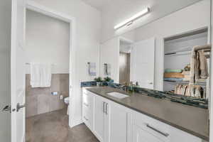 Bathroom with tile walls, vanity, and toilet