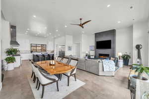 Dining room featuring a tiled fireplace and ceiling fan