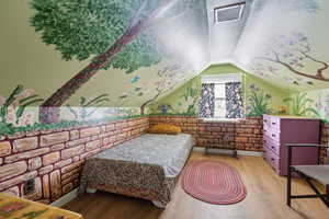 Bedroom featuring vaulted ceiling and light wood-type flooring