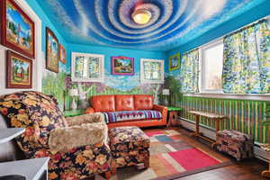 Living area with wood-type flooring and a baseboard heating unit