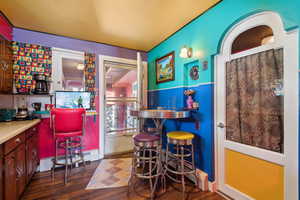 Bar featuring a baseboard heating unit and dark hardwood / wood-style flooring