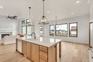 Kitchen featuring an island with sink, light brown cabinetry, sink, and light hardwood / wood-style flooring