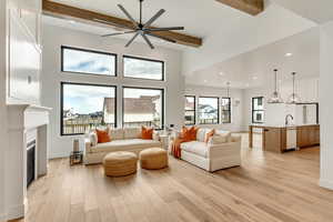 Living room with sink, beam ceiling, plenty of natural light, and light wood-type flooring