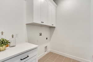 Laundry room featuring hookup for a washing machine, electric dryer hookup, and cabinets