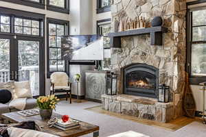 Living room featuring french doors, a towering ceiling, and a fireplace