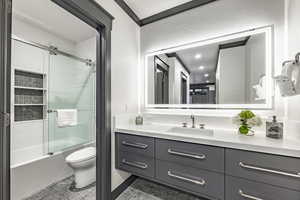 Full bathroom with vanity, combined bath / shower with glass door, tile patterned floors, and toilet