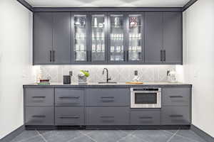 Bar with stainless steel oven, sink, and gray cabinetry