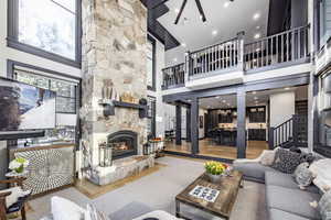 Living room featuring a towering ceiling, hardwood / wood-style floors, and a fireplace