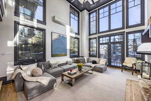 Living room with an AC wall unit and french doors