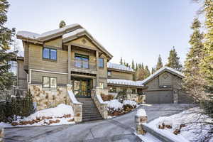 View of front of house featuring a balcony, a garage, and an outdoor structure