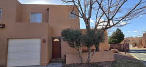 Pueblo revival-style home with a garage