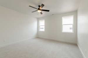 Spare room featuring ceiling fan and light carpet