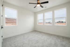 Carpeted spare room with ceiling fan