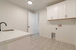 Washroom with cabinets, washer hookup, hookup for an electric dryer, and sink