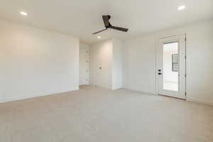 Carpeted empty room featuring ceiling fan