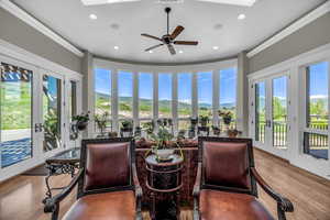 Sunroom featuring a mountain view, a skylight, french doors, and ceiling fan